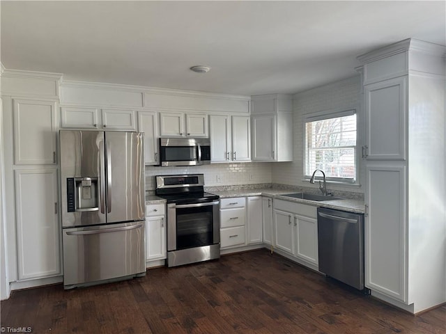 kitchen featuring stainless steel appliances, dark wood-type flooring, a sink, and light countertops