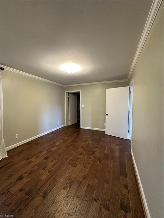 unfurnished room featuring dark wood-style floors, crown molding, and baseboards