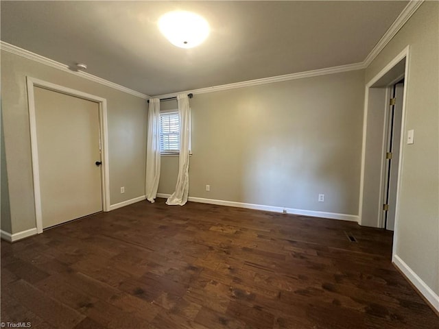 spare room featuring dark wood-style floors, baseboards, and ornamental molding