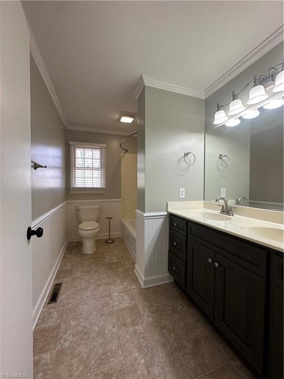 bathroom featuring ornamental molding, wainscoting, a sink, and visible vents