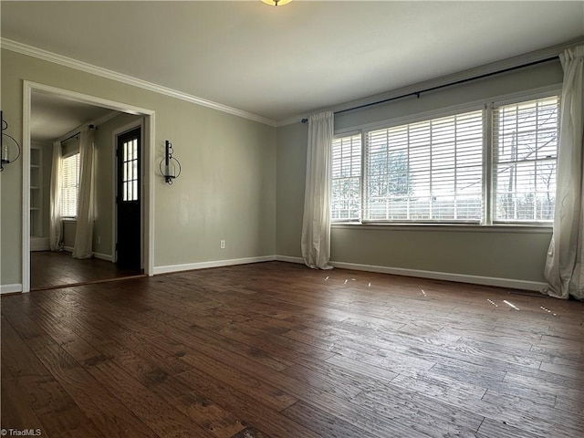 spare room with plenty of natural light, crown molding, and dark wood-style flooring