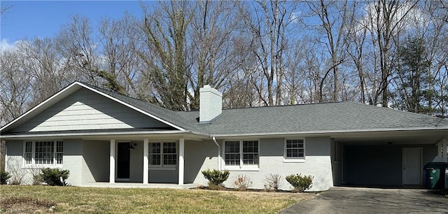 ranch-style house featuring brick siding, driveway, a carport, a front lawn, and a chimney