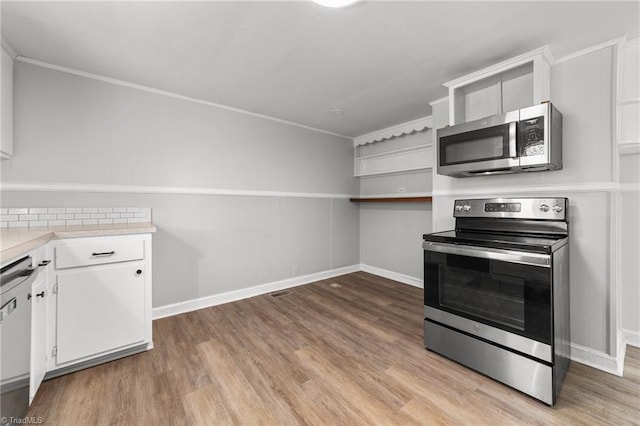 kitchen featuring white cabinetry, stainless steel appliances, crown molding, and light hardwood / wood-style flooring