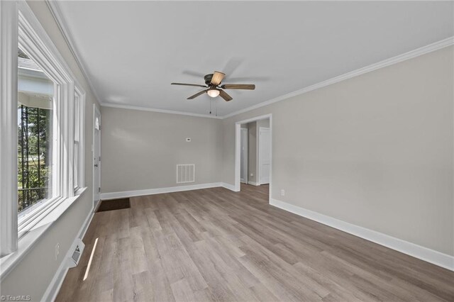 4108 Walker Ave, Greensboro, NC 27407 - empty room featuring plenty of natural light, a ceiling fan, wood finished floors, and crown molding