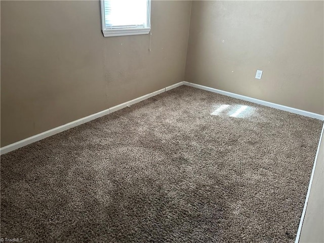 carpeted spare room featuring baseboards