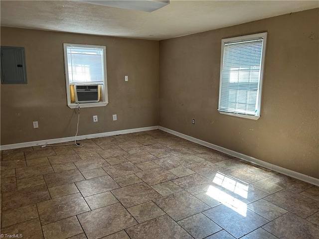 spare room featuring electric panel, baseboards, and cooling unit