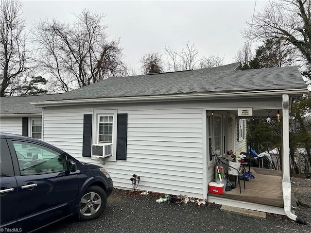 view of home's exterior featuring a shingled roof and cooling unit