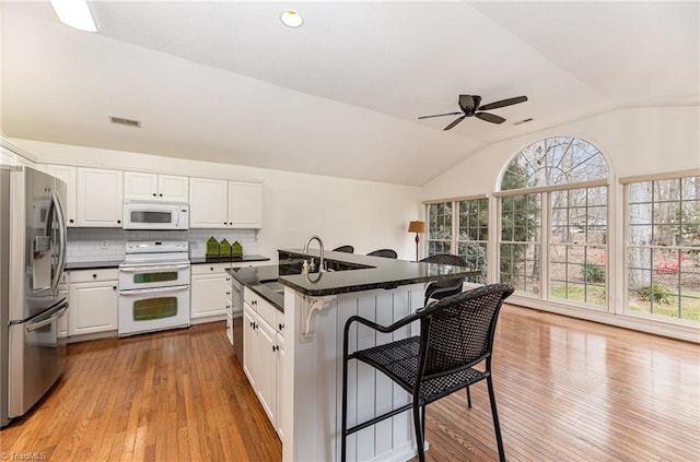 kitchen with white cabinetry, white appliances, and a center island with sink