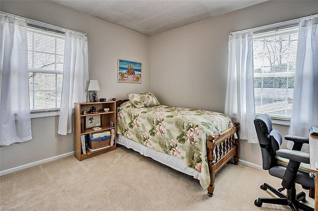 bedroom featuring carpet, a textured ceiling, and baseboards