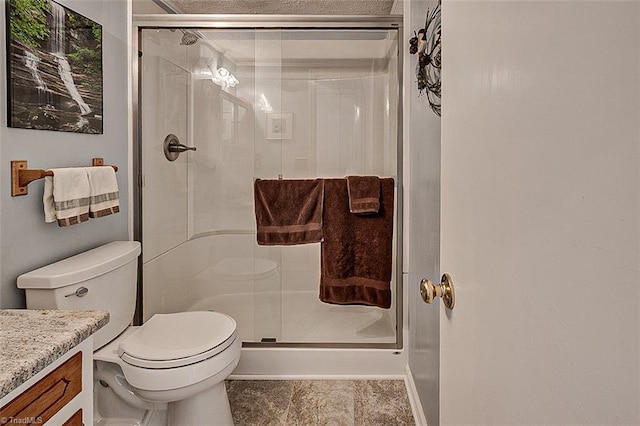 bathroom with tile patterned flooring, toilet, a shower stall, and vanity