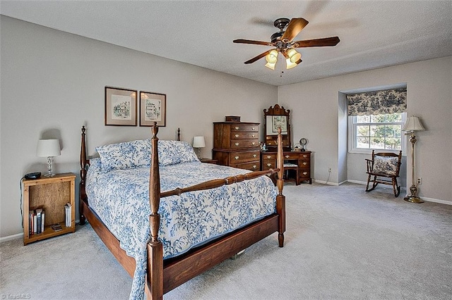 bedroom featuring light carpet, ceiling fan, baseboards, and a textured ceiling