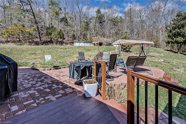 wooden terrace with a yard, a patio, and a pool