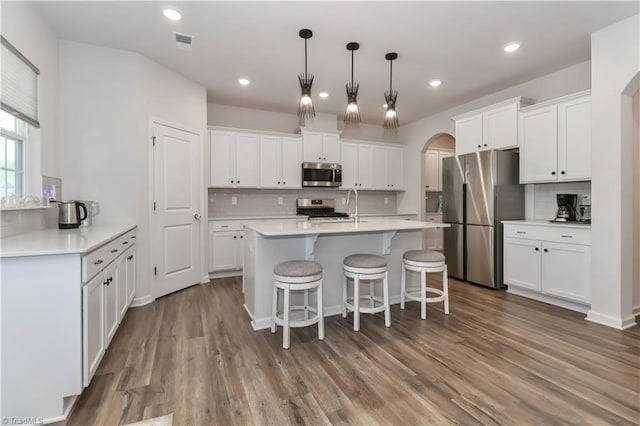 151 Outrigger Ln, Troutman, NC 28166 - kitchen featuring appliances with stainless steel finishes, arched walkways, decorative backsplash, white cabinets, and recessed lighting