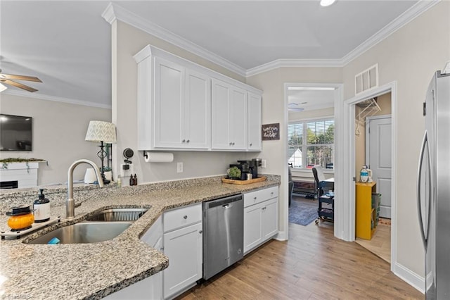 kitchen with stainless steel appliances, a sink, light wood finished floors, and ornamental molding