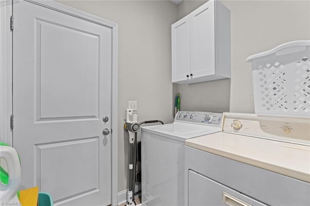 washroom featuring washer and clothes dryer and cabinet space