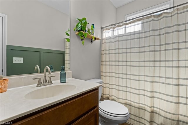 full bath featuring a shower with curtain, vanity, and toilet