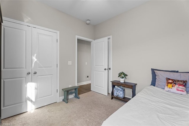 bedroom featuring a closet, carpet flooring, attic access, and baseboards