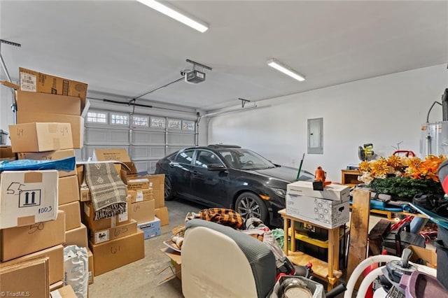 garage featuring water heater, electric panel, and a garage door opener