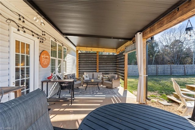 wooden terrace featuring outdoor dining space, fence, a patio, and an outdoor hangout area