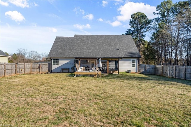 rear view of property with a fenced backyard and a lawn