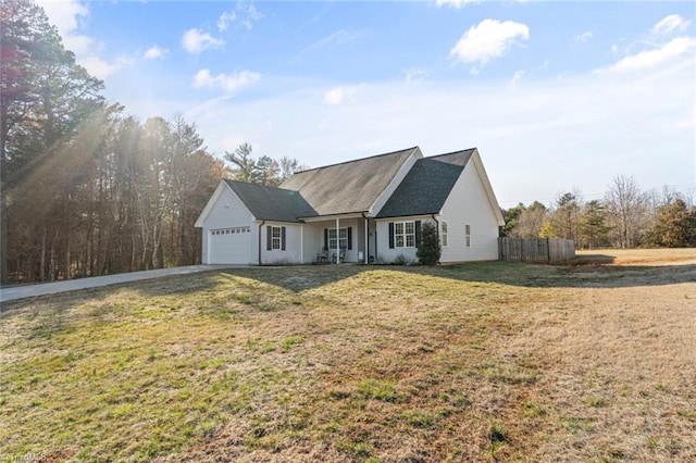 ranch-style house with driveway, an attached garage, fence, and a front yard