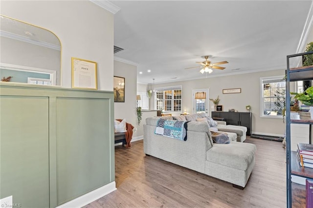 living area featuring crown molding, plenty of natural light, and wood finished floors