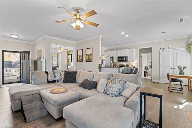 living room with recessed lighting, ceiling fan with notable chandelier, visible vents, light wood-style floors, and ornamental molding