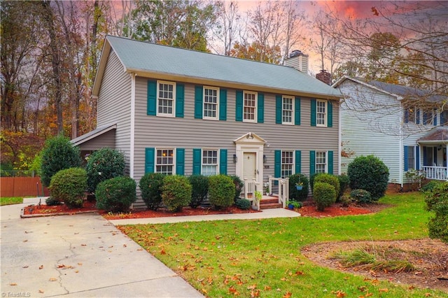 colonial inspired home with a lawn