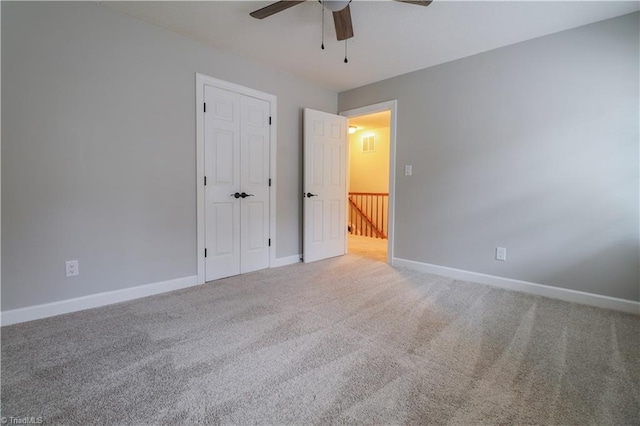 unfurnished bedroom featuring carpet, ceiling fan, and a closet