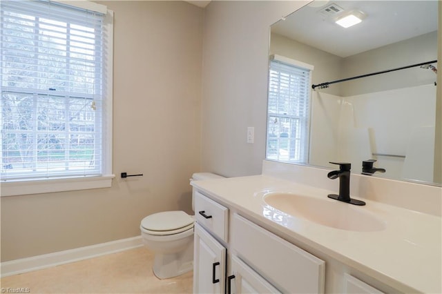 bathroom with toilet, vanity, a wealth of natural light, and walk in shower