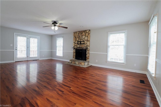 unfurnished living room with dark wood-type flooring, ceiling fan, and a fireplace