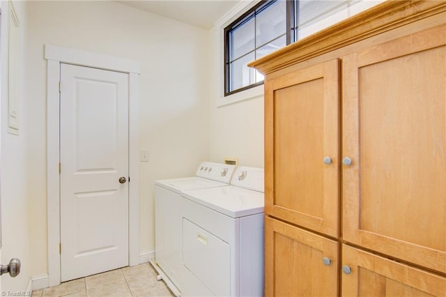 laundry area with cabinets, light tile patterned floors, and washing machine and dryer