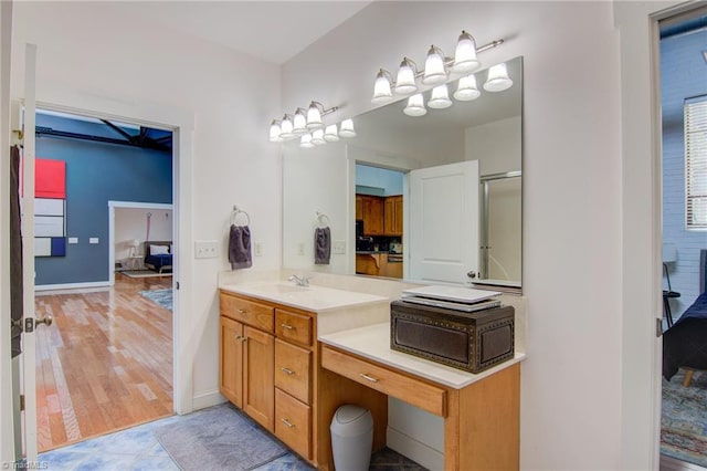 bathroom with vanity, a shower with shower door, and hardwood / wood-style floors