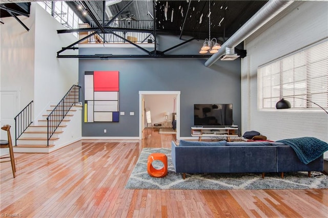 living room featuring a towering ceiling and hardwood / wood-style flooring