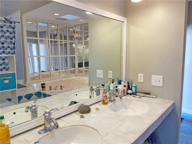 bathroom featuring a sink, a bathing tub, and double vanity