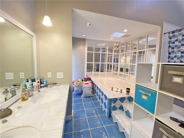 bathroom with double vanity, a skylight, a bath, tile patterned floors, and a sink