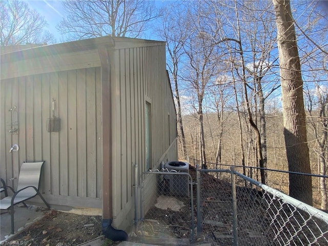 view of outdoor structure featuring a gate, cooling unit, and fence