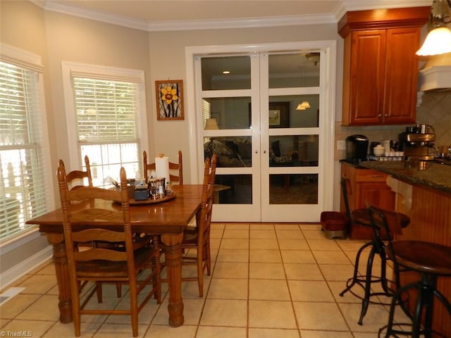 dining area featuring ornamental molding and light tile patterned floors