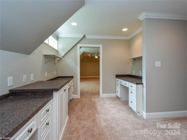 kitchen featuring open shelves, dark countertops, crown molding, light colored carpet, and a ceiling fan