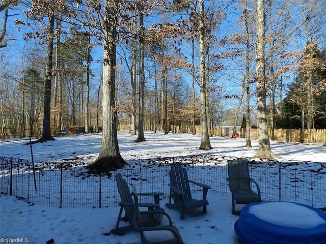 snowy yard featuring fence