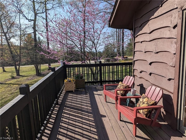 wooden terrace featuring a lawn