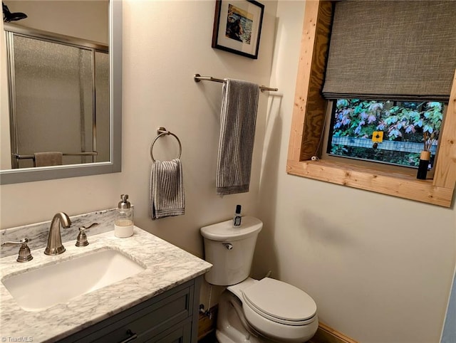 bathroom with walk in shower, vanity, and toilet