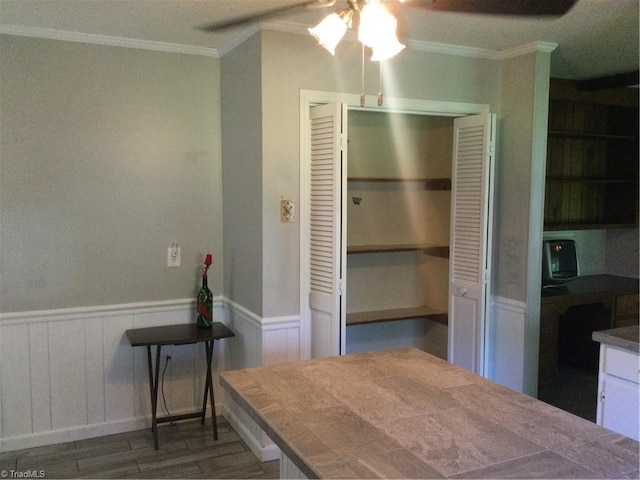 interior space featuring ceiling fan, ornamental molding, dark hardwood / wood-style floors, and a closet