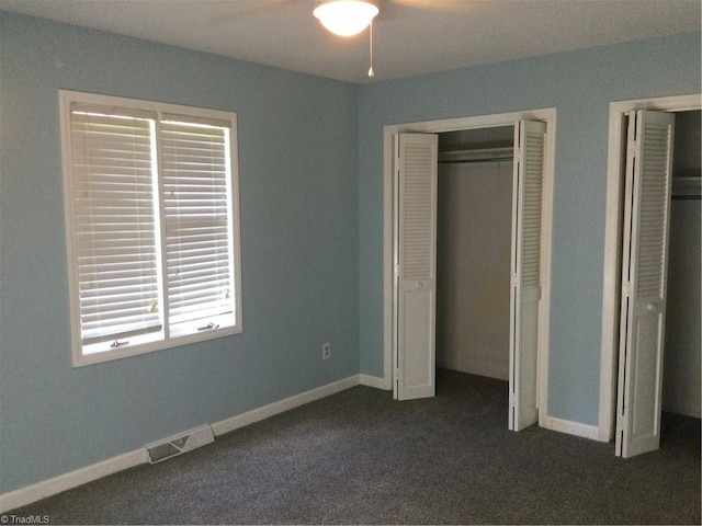 unfurnished bedroom with dark colored carpet