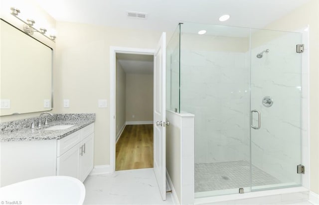 bathroom with a shower with door and vanity