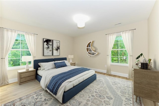 bedroom featuring hardwood / wood-style flooring and multiple windows