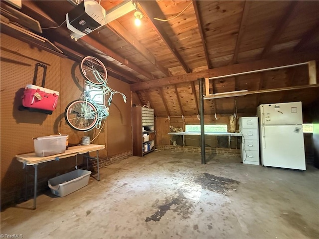 interior space featuring concrete flooring, a garage, and vaulted ceiling