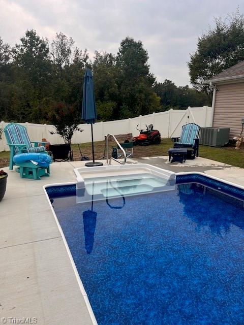 view of swimming pool with central AC and a patio