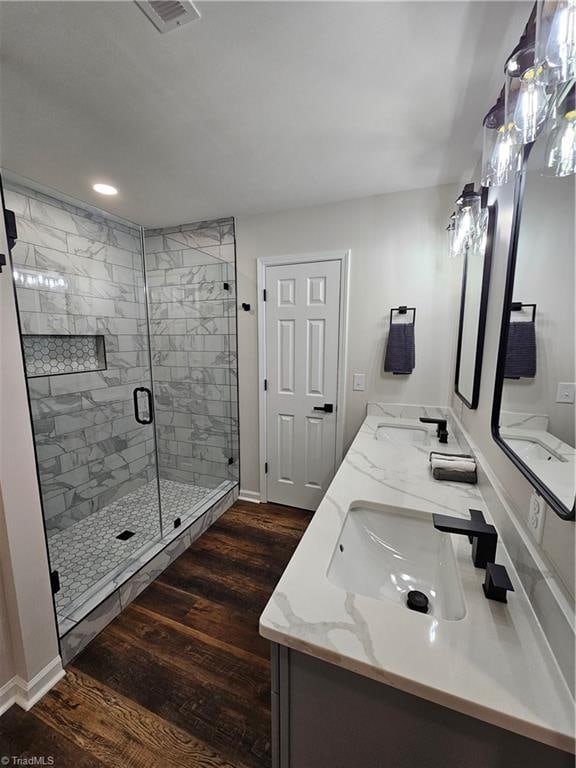 bathroom featuring an enclosed shower, vanity, and hardwood / wood-style flooring