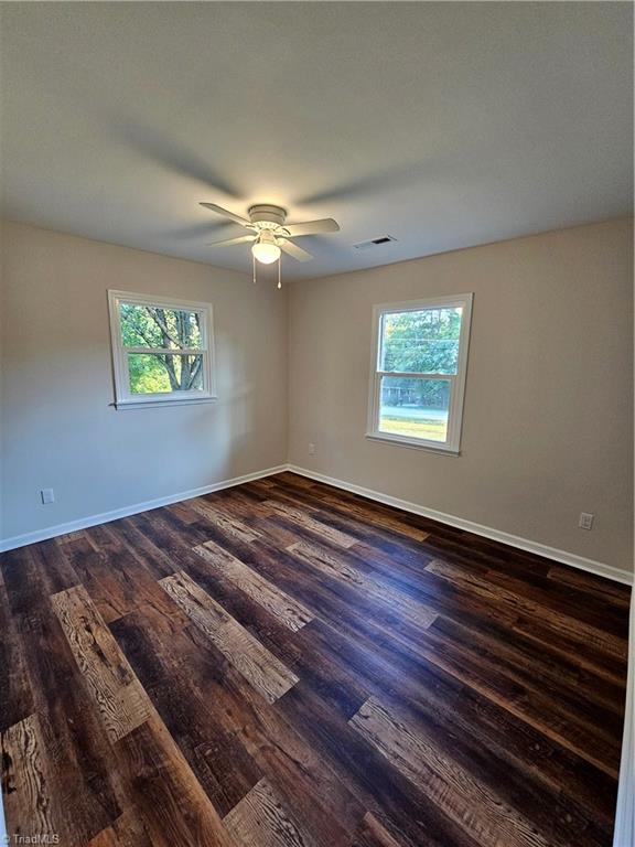 empty room featuring dark hardwood / wood-style floors and ceiling fan